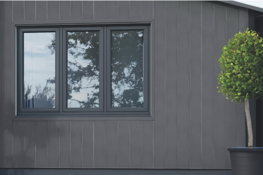 Carlos kültéri WPC falburkolat szürke homlokzati felületen, ablak környezetében.